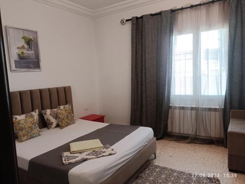 ein Schlafzimmer mit einem großen Bett und einem Fenster in der Unterkunft Fufa Apartment in Monastir