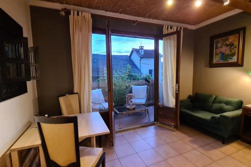 un salon avec un canapé vert et une table dans l'établissement Maisonnette à 2 pas de la Seine, à La Frette-sur-Seine