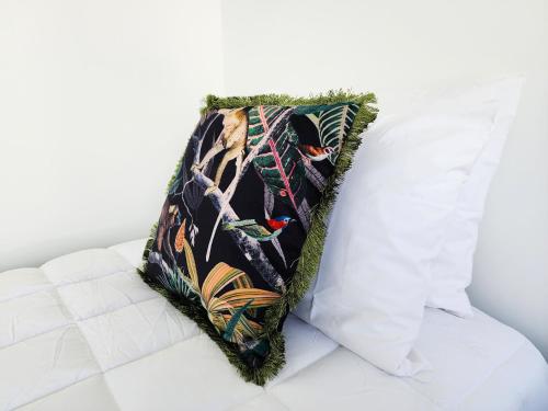 a pillow sitting on top of a white couch at U Suites on Trieste Way in Paraparaumu