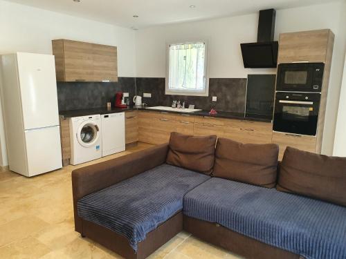 un salon avec un canapé et une cuisine dans l'établissement Petite maison en campagne, à Pernes-les-Fontaines