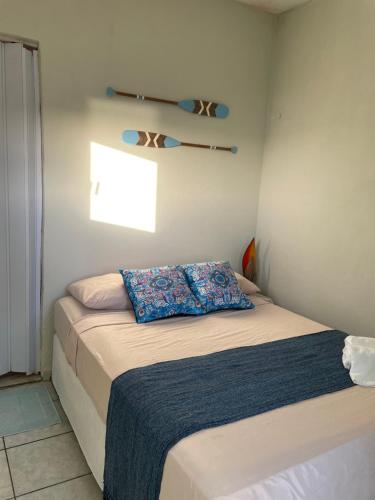 a bedroom with a bed with a blue pillow on it at Vista Surf Pipa Hostel in Pipa
