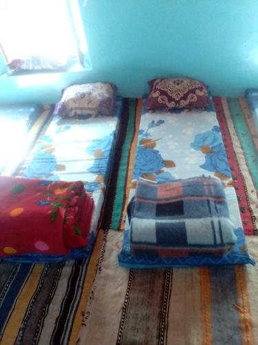 dos camas sentadas una al lado de la otra en una habitación en Gite atlas, en Megdaz