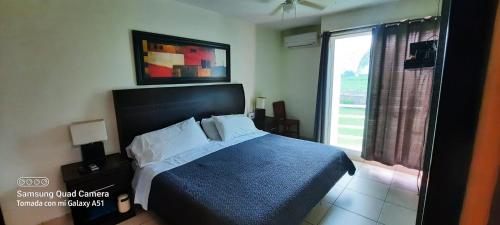 1 dormitorio con 1 cama con manta azul y ventana en Familiar, casa con alberca y jacuzzi, en Yautepec