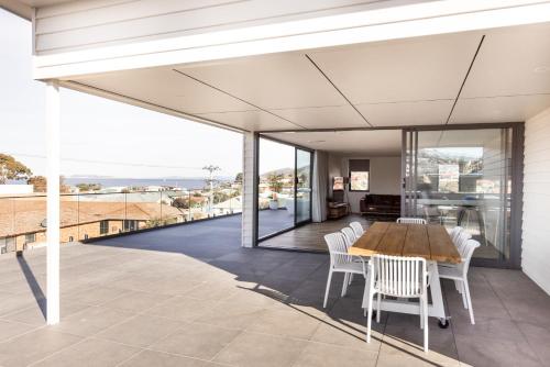 an open deck with a table and chairs on a house at Little Island Apartments in Hobart