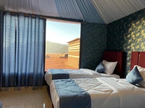 瓦迪拉姆的住宿－超越瓦迪朗姆露營地，一间卧室设有两张床和大窗户