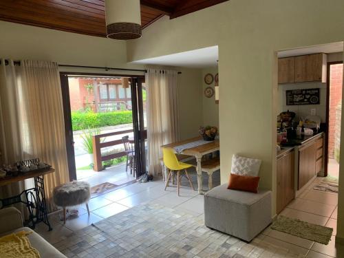 ein Wohnzimmer mit einer Küche und einem Tisch mit Stühlen in der Unterkunft Chalé Refidim in Gravatá