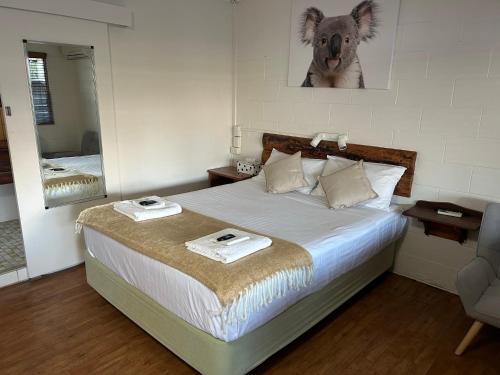 Kilcoy Motel في Kilcoy: غرفة نوم عليها سرير وفوط