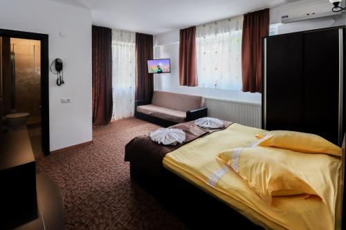 バイレ・オラネシュティにあるBelvedere Olanestiのベッドと椅子付きのホテルルーム