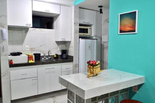una cocina con armarios blancos y una pared azul en Charming 1-BR Apartment in Boa Viagem - with Ocean View, en Recife