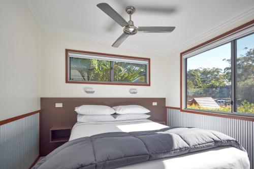 a bedroom with a bed and a ceiling fan at NRMA South West Rocks Holiday Park in South West Rocks