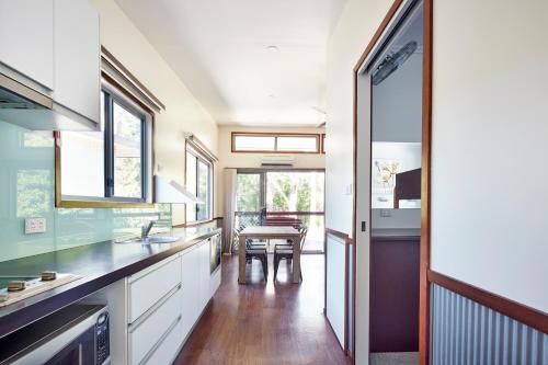 a kitchen with white cabinets and a dining room with a table at NRMA South West Rocks Holiday Park in South West Rocks