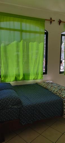 a bedroom with a bed with a green cover at Taxco de mis amores in Taxco de Alarcón