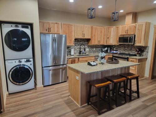 a kitchen with a refrigerator and a counter with stools at Cozy Apartment Between the Rivers in Soldotna
