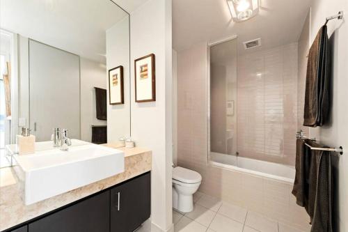 a white bathroom with a sink and a toilet at Luxury 1BR Apartment - Golf & Hot Springs Retreat! in Fingal