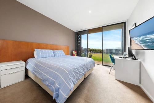 a bedroom with a bed and a flat screen tv at Luxury 1BR Apartment - Golf & Hot Springs Retreat! in Fingal