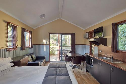 a bedroom with a bed and a kitchen and a living room at NRMA South West Rocks Holiday Park in South West Rocks