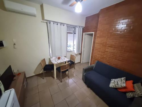 a living room with a blue couch and a brick wall at Copacabana Posto 6 até 3 pessoas in Rio de Janeiro