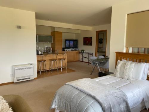 a bedroom with a large bed and a kitchen at Lake Vista Lodge in Taupo