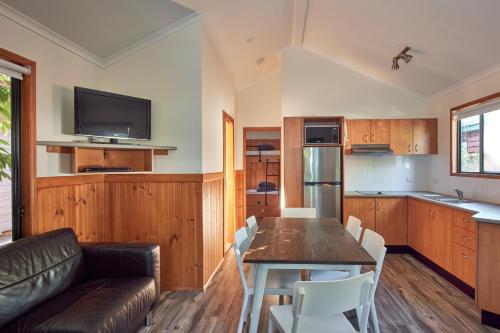 a living room with a couch and a table with chairs at NRMA South West Rocks Holiday Park in South West Rocks
