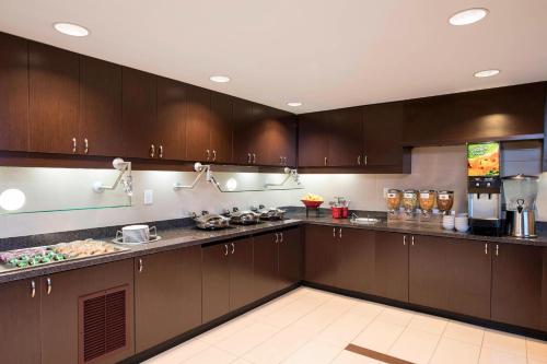a kitchen with brown cabinets and a counter top at Residence Inn by Marriott Austin - University Area in Austin