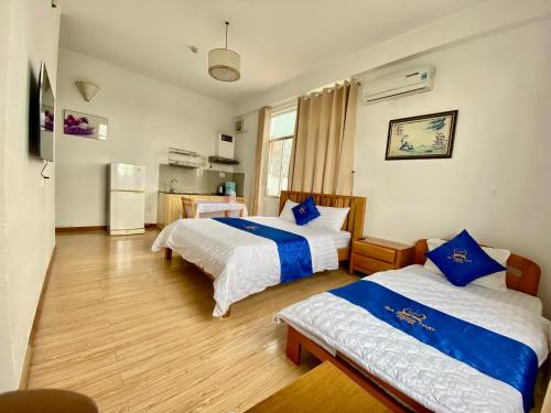 a hotel room with two beds and a refrigerator at hotel Gia Phong Phat in Xóm Mỹ Thanh