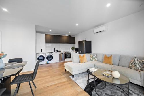 a living room with a couch and a table at Remarkable Mountain Scene - A Modern Escape in Frankton Wharf