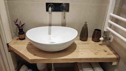 un bagno con lavandino bianco su un bancone in legno di B&B Magnifico Messere a Firenze