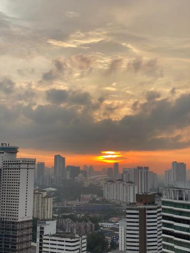 a city skyline with the sun setting in the distance at RumaKL at TR Residence Titiwangsa Sentral in Kuala Lumpur