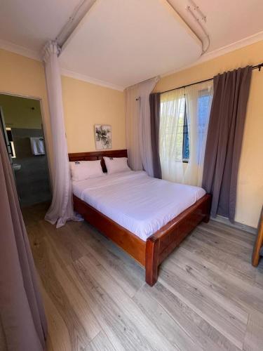 a bedroom with a large bed with white sheets at SEGA LODGE RESORT in Sega