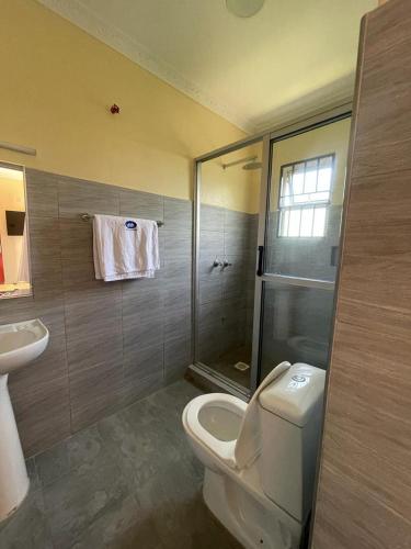 a bathroom with a toilet and a sink and a shower at SEGA LODGE RESORT in Sega