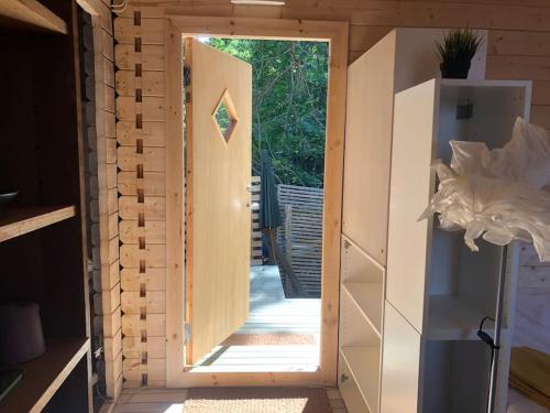 an open door to a tiny house with a porch at Houses by the sea near the city in Lidingö