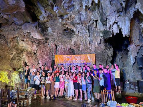 a group of people posing in front of a cave at Yen Nhi Homestay Ban Gioc in Cao Bằng