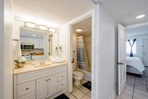 a bathroom with a sink and a toilet and a bedroom at Royal Retreat-Amazing view-King bed-1 bedroom-Full kitchen-Free parking-Self check-in in Myrtle Beach