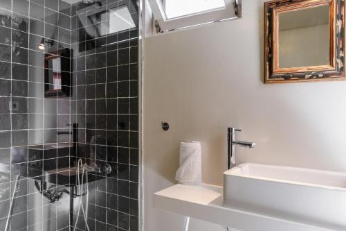 a bathroom with a sink and a shower at Baga de Sal Wine Guesthouse in Aveiro