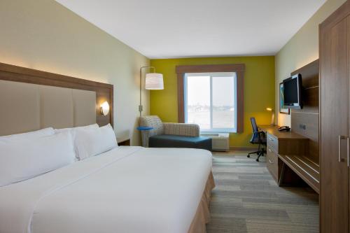 una camera d'albergo con un grande letto e una TV di Holiday Inn Express Hotel & Suites Ontario, an IHG Hotel a Ontario