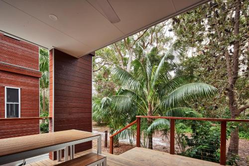 a balcony with a wooden bench on a wooden deck at NRMA South West Rocks Holiday Park in South West Rocks