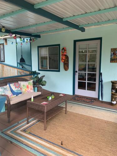 a living room with a couch and a table at Manta Soul Tiki Cottage in Kealakekua