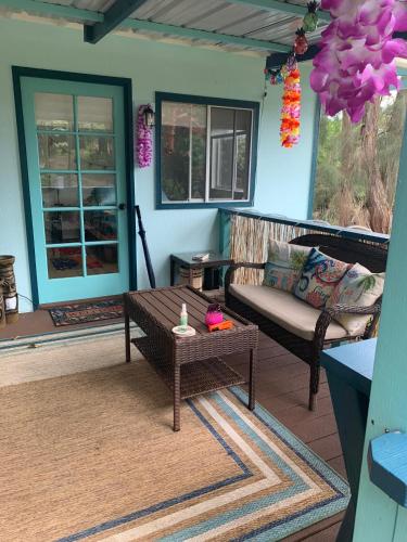 a porch with a couch and a coffee table at Manta Soul Tiki Cottage in Kealakekua