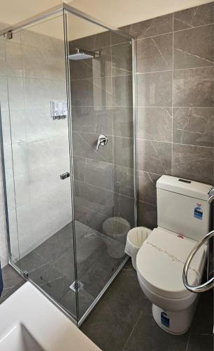 a bathroom with a shower and a toilet at Blue Lake Motel in Mount Gambier