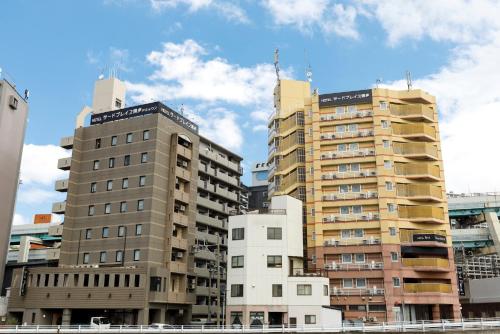 un grupo de edificios altos en una ciudad en HOTEL Third Place Hakata, en Fukuoka