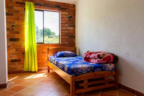 Cette petite chambre comprend un lit et une fenêtre. dans l'établissement Finca La Piscina, disfrute total, à Marinilla