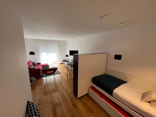 a bedroom with a bed and a living room at Apartamento do Atlântico in Ponta Delgada