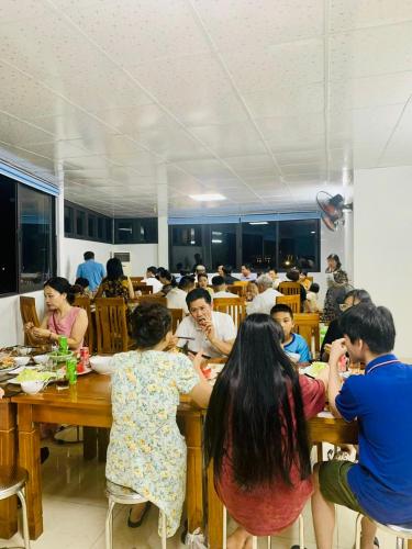 a group of people sitting at tables in a restaurant at Hồng Anh 2 Hotel in Ha Long