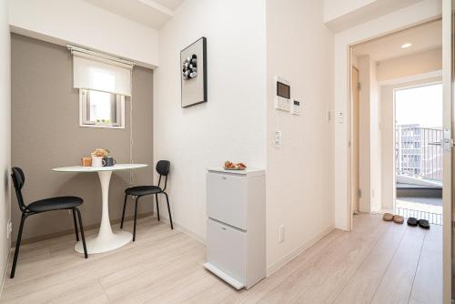 a living room with a table and chairs and a window at ZAITO Kikukawa SRS Apartment 新築マンション in Tokyo