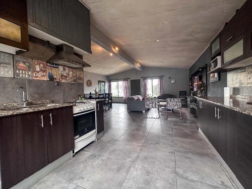 cocina grande con armarios de madera y sala de estar. en Casa en zona residencial Mendoza en Luján de Cuyo