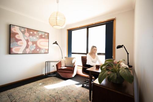 a woman sitting in a chair in a room with a window at Madsen Retreat in Penguin