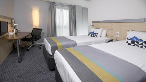 a hotel room with two beds and a desk at Holiday Inn Express Hull City Centre by IHG in Hull