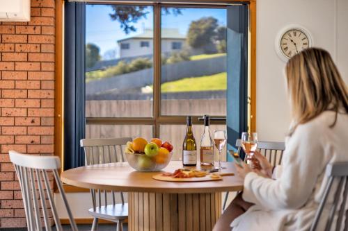 a woman sitting at a table with a glass of wine at Madsen Retreat in Penguin