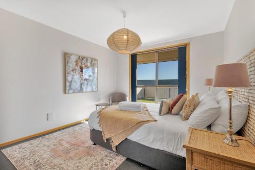 a bedroom with a bed and a large window at Madsen Retreat in Penguin