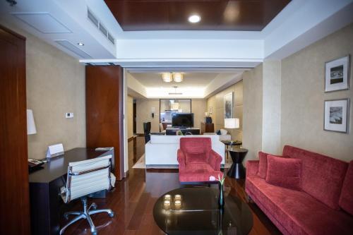 a living room with a couch and red chairs at The Imperial Mansion, Beijing - Marriott Executive Apartments in Beijing